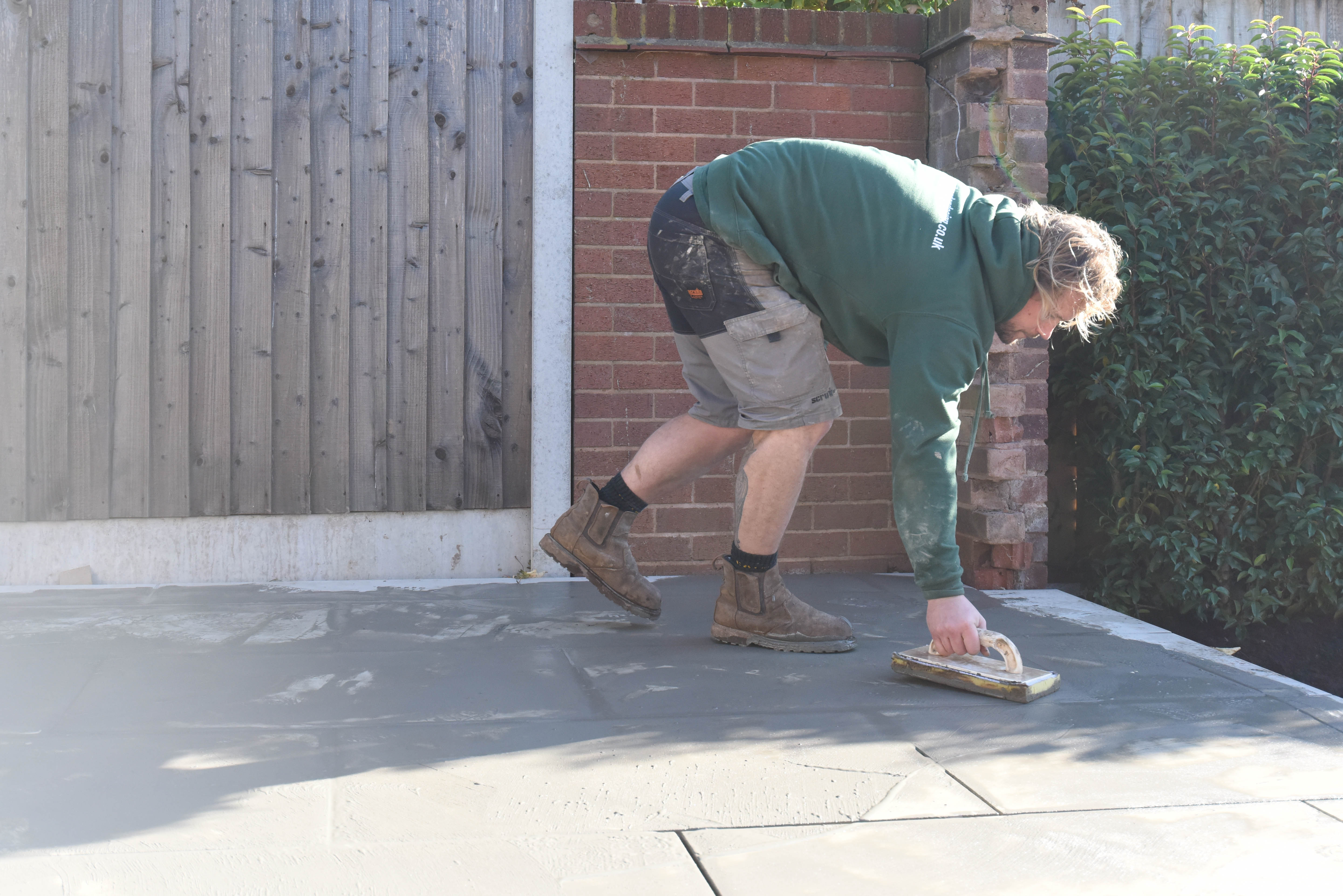 Excess grout being removed from the surface of porcelain tiles using a damp sponge grout float
